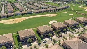 Un quartier résidentiel avec des maisons, un terrain de golf et un ciel dégagé.