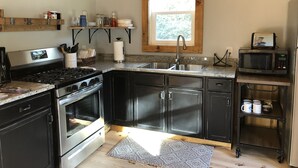 Uma cozinha moderna com eletrodomésticos de aço inoxidável, vigas de madeira e uma janela que traz luz natural.