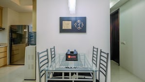 Een eethoek met een glazen tafel, stoelen en een waterdispenser.