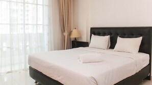 A neatly made bed with white linens, a black headboard, and a rolled white towel on the bed. - Fully Furnished with Cozy Design 2BR The Bellezza Apartment (Jakarta)