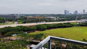 Blick auf eine Stadtlandschaft mit Parkhaus, Autobahn und einer Grünfläche.
