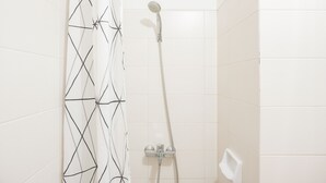A shower with a handheld showerhead and a wall-mounted faucet. - Comfortable and Minimalist Studio Apartment at Woodland Park Residence (Jakarta)
