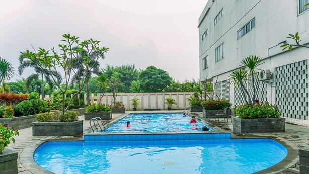 A swimming pool surrounded by planters and a building. - Simple and Cozy Living Studio Apartment at Margonda Residence (Depok)