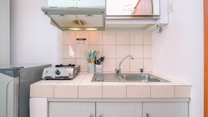 A kitchen with white cabinets, a stainless steel sink, and a toaster. - Simple and Cozy Living Studio Apartment at Margonda Residence (Depok)