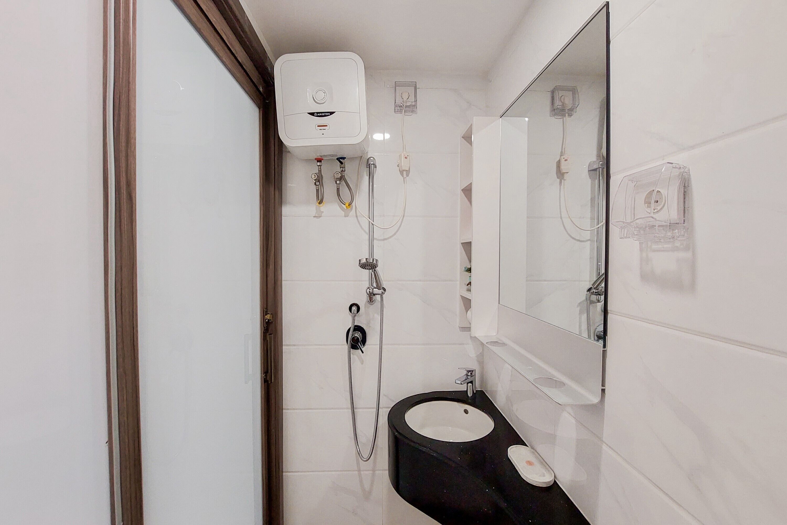 A bathroom with a black sink, a mirror, and a white toilet.