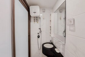 Un baño con un lavabo negro, un espejo y un inodoro blanco.