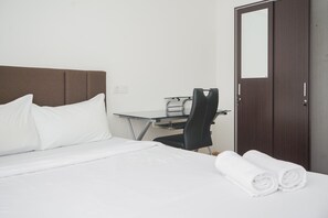 A hotel room with a bed, a desk, a chair, and a wardrobe. - Comfort 2BR at Sky House BSD Apartment (Pagedangan)