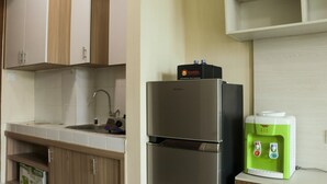 Eine Küche mit Holzausstattung, einem Edelstahlkühlschrank, einem Wasserspender und einem Spülbecken.