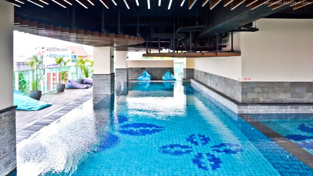 Une piscine dont le fond est carrelé et dont l’eau est d’un bleu limpide.
