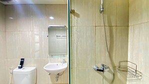 Une salle de bain avec des toilettes, un lavabo et une douche.