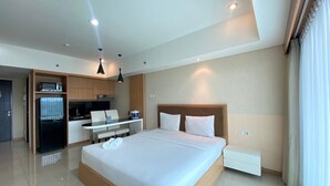 Une chambre d’hôtel moderne dotée d’un grand lit, d’un coin repas séparé et d’une kitchenette.