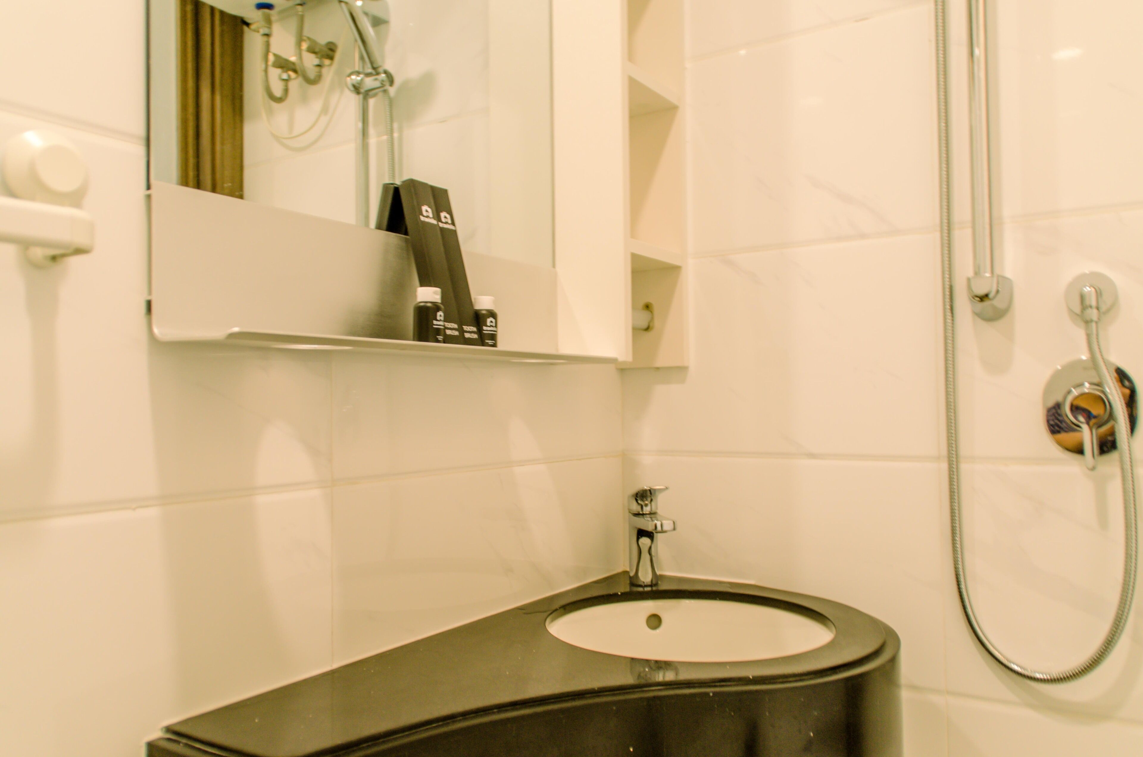 A bathroom with a black sink, a mirror, and a shower.