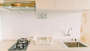 Una cocina con estufa a gas, un fregadero y un escurreplatos.