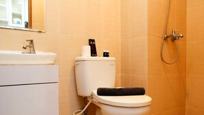 Een badkamer met toilet, wastafel en douche.