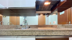Une cuisine dotée de plans de travail en granit, d’appareils électroménagers en acier inoxydable et d’un design moderne.