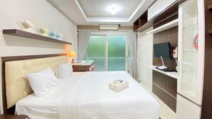 Une chambre d’hôtel équipée d’un lit, d’un bureau, d’une télévision et d’une armoire.