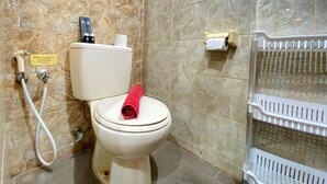 Une salle de bain équipée de toilettes, d’un bidet et d’un sèche-mains.