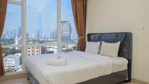 Ein Hotelzimmer mit einem großen Bett, Blick auf die Stadt und einem Vorhangfenster.