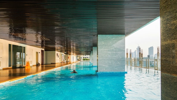 Ein beheiztes Hallenbecken mit Blick auf die Stadt, ein Holzboden und ein modernes Decken design.