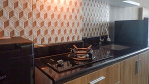Una cocina moderna con estufa a gas, encimera negra y salpicadero estampado.