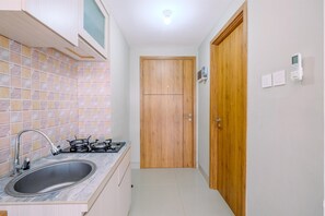 Room | Private kitchen | Fridge, stovetop, cookware/dishes/utensils - Elegant Wide View Studio Apartment at LRT City Jatibening (Bekasi)
