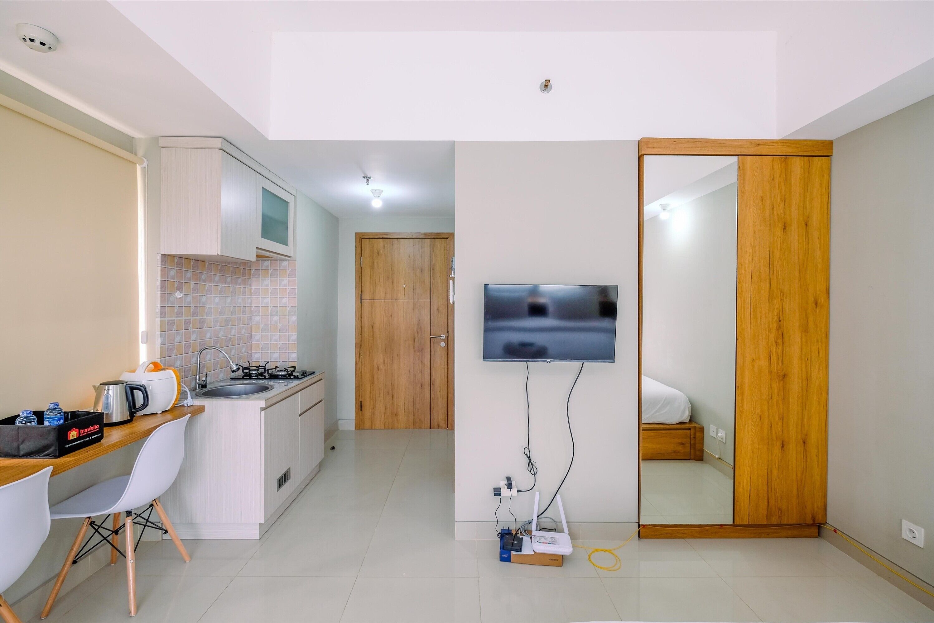 A compact kitchen with a microwave, sink, and a small dining area with chairs.