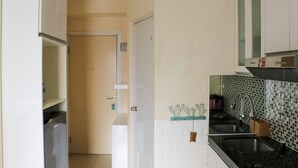 A kitchen with white cabinets, a black countertop, and a tiled backsplash.