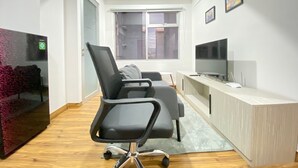 A modern office space with a desk, chair, and television. - Modern and Well Furnished 2BR at Jarrdin near Cihampelas Walk (Bandung)