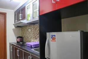 Une cuisine équipée d’un réfrigérateur, de placards et d’une machine à café.