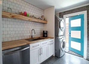 Compact kitchen with sink, dishwasher, and washer/dryer.