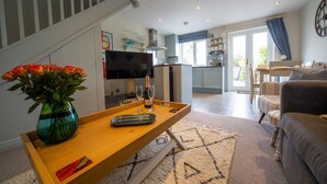 Un salon moderne avec une table basse en bois, un canapé et un téléviseur.