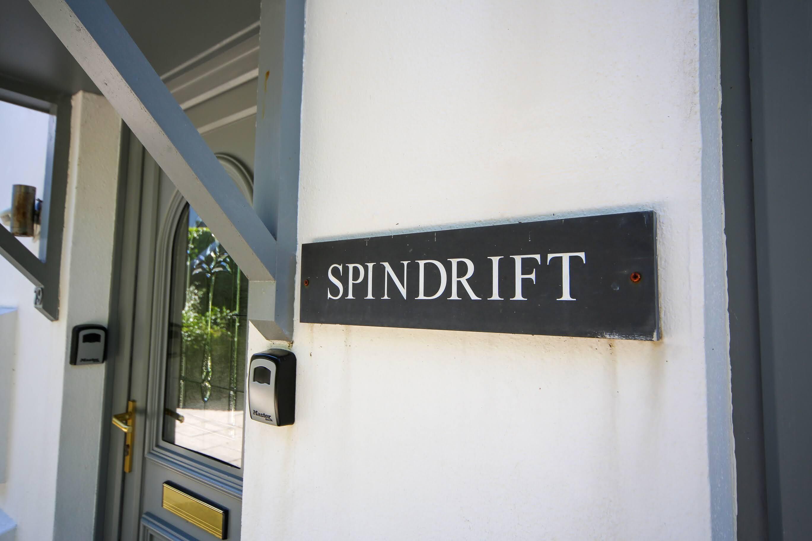 A sign reading "SPINDRIFT" mounted on a white wall.