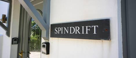 A sign reading "SPINDRIFT" mounted on a white wall.