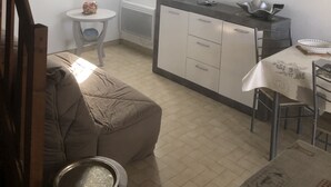 A compact kitchen with a dining area, a sofa, and a TV mounted on the wall. - COMFORTABLE VILLA NEAR EUROPARK (Vias)
