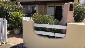 A house with a beige exterior, a tiled roof, and a white gate. - COMFORTABLE VILLA NEAR EUROPARK (Vias)
