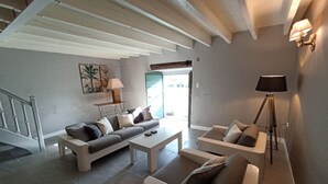 Un salon moderne comprenant un canapé, une table basse et un lampadaire.