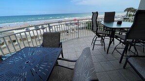 Ein Balkon mit Blick auf den Strand, ausgestattet mit Sitzgelegenheit und einem Tisch.