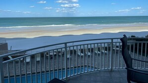 Ein Balkon mit Blick auf Strand und Meer.