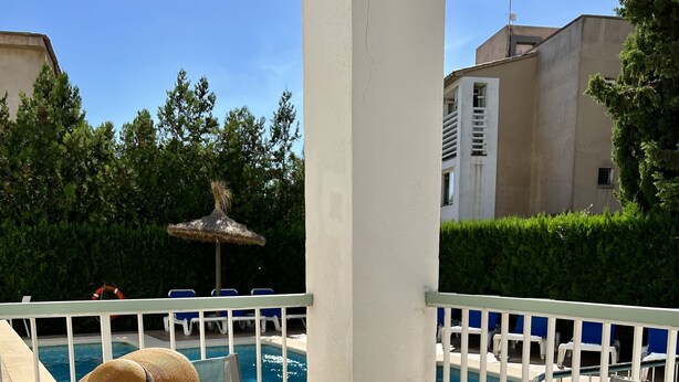 A poolside area with a table and chairs, a straw hat, and a magazine. - Cielo 103. Upper Ground Floor, Pool View. (Pollença)