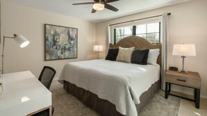 A bedroom with a bed, bedside tables, a desk, a ceiling fan, and a window with blinds. - Jenks Spectacular Spain Ranch-Close to Five Oaks (Jenks)