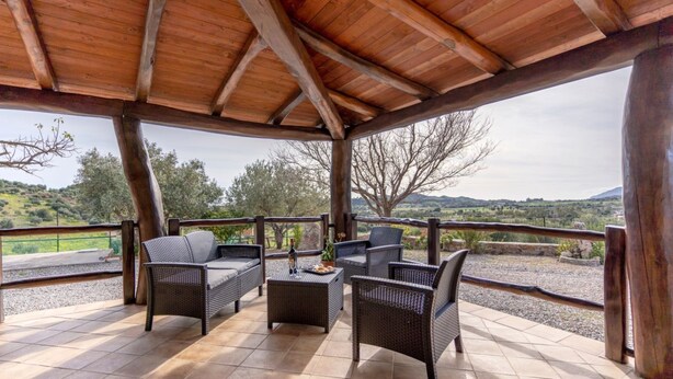 A covered outdoor seating area with wicker furniture and a view of the countryside. - Su Castangiu1, flat in villa with swimming pool and 5-a-side football pitch (tertenia)