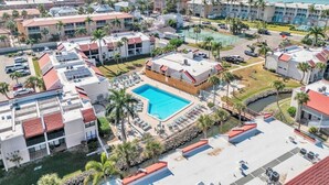 A resort with a central pool, multiple buildings, and a view of the ocean. - Runaway Bay 283 by Duncan Real Estate (Bradenton Beach)