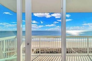 Un balcón con vista al océano y la playa.