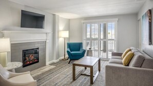 Ein Wohnzimmer mit Kamin, einer Couch, einem blauen Sessel und einem Couchtisch.