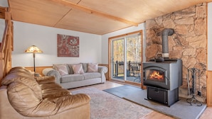 A cozy living room with a stone wall, a fireplace, a sofa, and a lamp. - Big Indian near
 Full Moon Resort Spillian Onteora Mountain House Ski Belleayre  (Big Indian)
