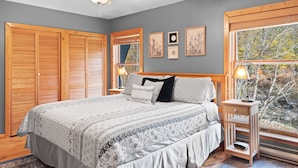 A bedroom with a bed, wooden closet, window with view, ceiling fan, and wall art. - Big Indian near
 Full Moon Resort Spillian Onteora Mountain House Ski Belleayre  (Big Indian)
