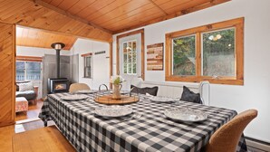 A cozy dining area with a checkered tablecloth, a central vase, and a rustic wooden ceiling. - Big Indian near
 Full Moon Resort Spillian Onteora Mountain House Ski Belleayre  (Big Indian)