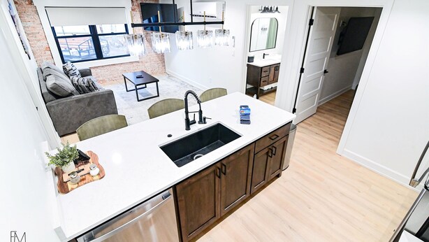 A modern kitchen with a central island, built-in appliances, and a dining area with a sofa and chairs.