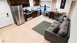 Una cocina moderna con electrodomésticos de acero inoxidable, armarios de madera y un comedor con mesa y sillas.