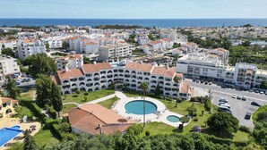 Un hôtel doté d’une cour intérieure, d’une piscine et offrant une vue sur la mer.